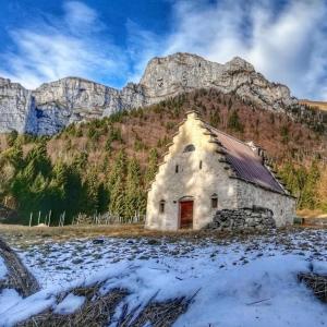 Sovramonte的住宿－Tiny House Dolomiti，一座古老的石头建筑,背景是一座山