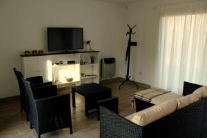 a living room with a couch and chairs and a television at Casita en Chacras in Ciudad Lujan de Cuyo