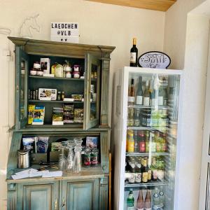 a kitchen with a refrigerator and a shelf with alcohol at Vor lauter Bäumen B&B in Zorge