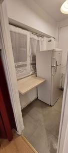 Una pequeña cocina con un refrigerador blanco y una ventana. en Valentina Studio, en Baia Mare