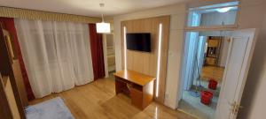 a living room with a table and a television on a wall at Valentina Studio in Baia Mare