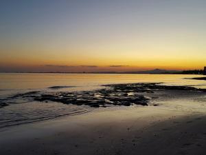 a sunset on a beach with the ocean at PylaApts - Apartments near the beach in Pyla