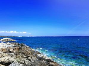 a large body of water with rocks and the ocean at PylaApts - Apartments near the beach in Pyla