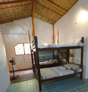 a room with two bunk beds in a house at El Gordo's Seaside Adventure Lodge in El Nido
