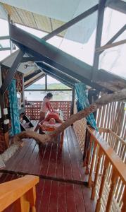 a woman sitting on the deck of a boat at El Gordo's Seaside Adventure Lodge in El Nido