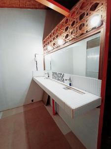uma casa de banho com um lavatório e um espelho em El Gordo's Seaside Adventure Lodge em El Nido