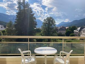 a white table and chairs on a balcony with a view at Les Mélèzes 1 Studio in Barcelonnette