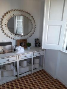 uma casa de banho com um toucador branco e um espelho. em Moradia de férias Casa do Chorão - Montargil em Montargil