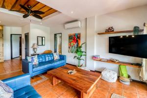 ein Wohnzimmer mit einem blauen Sofa und einem Tisch in der Unterkunft Casa Mimosa in Playa Flamingo