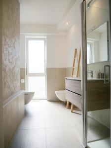 La salle de bains est pourvue d'un lavabo, de toilettes et d'un miroir. dans l'établissement Ristoro 5 - Splendido 100 mq, nuovo e luminoso, à Preganziol