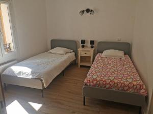 馬洛塞納的住宿－La suite du beffroi，一间卧室设有两张床和一张桌子及窗户
