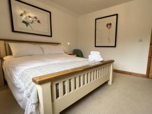 a bedroom with a white bed and two pictures on the wall at North Gower Cottage in Llanmorlais