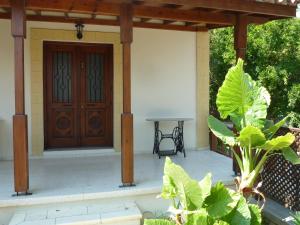eine Veranda mit einer Holztür und einem Tisch in der Unterkunft Farm House in Kyrenia