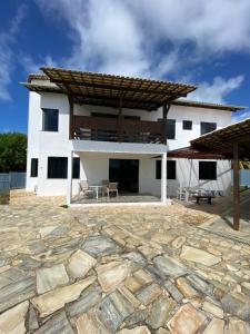 un gran edificio blanco con un patio de piedra en Exclusiva Casa na Melhor Praia de Aracaju, en Aracaju