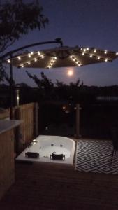 a hot tub under a string of lights at night at Luxury Glamping with lake & Mountain View in Culky
