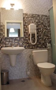 ein Badezimmer mit einem Waschbecken, einem WC und einem Spiegel in der Unterkunft Avenue in Schumen