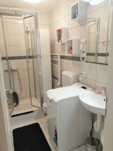 a white bathroom with a shower and a sink at APARTMAN D&D*** in Varaždin