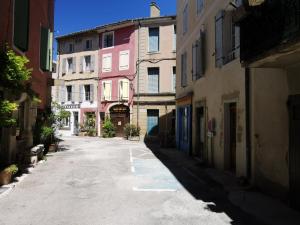 una strada vuota in un vicolo con edifici di La suite du beffroi a Malaucène