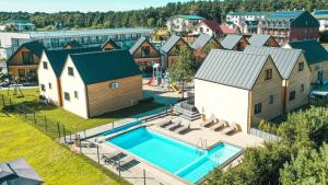 - une vue aérienne sur un village avec une piscine et des maisons dans l'établissement Huśtawka i Hamak - Domki z basenem nad morzem Ustka, à Ustka