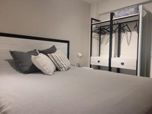 1 dormitorio con 1 cama con 2 almohadas en BE Apartments Vicente en Mendoza