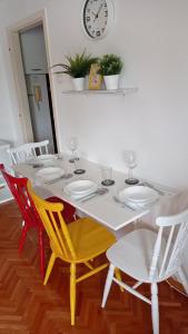 a dining room table with chairs and a clock on the wall at Colors of Cvjetno Apartment in Zagreb