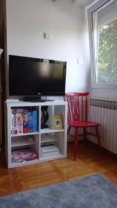 a white entertainment center with a flat screen tv at Colors of Cvjetno Apartment in Zagreb