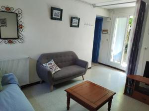 uma sala de estar com um sofá e uma mesa de centro em Gite les Glycines em Llupia