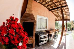 a room with a fireplace and a table and red flowers at Chalé vista incrível Monte Alegre Village in Monte Alegre do Sul