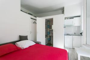 sypialnia z czerwonym łóżkiem i kuchnią w obiekcie Charming Parisian studio! w Paryżu