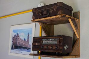 une ancienne radio et une valise sur une étagère dans l'établissement Chalé vista incrível Monte Alegre Village, à Monte Alegre do Sul