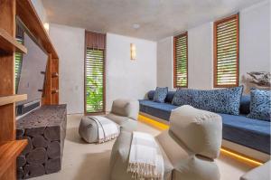 Una sala de estar con un sofá azul y sillas. en Punta Mita luxury home- Rock House, en Punta Mita