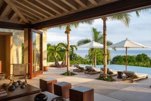 un patio al aire libre con tumbonas y sombrillas en Punta Mita luxury home- Rock House, en Punta Mita