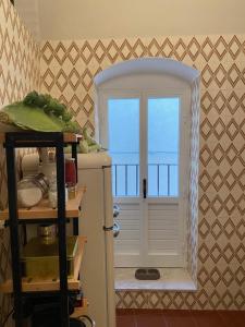 a kitchen with an open door and a window at Casa Antonio Noto in Noto