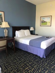 um quarto de hotel com duas camas e uma secretária em Capes Hotel em Virginia Beach