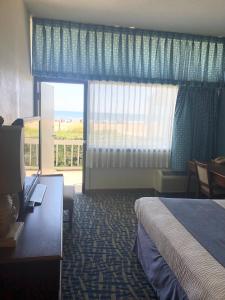 a hotel room with a bed and a view of the ocean at Capes Hotel in Virginia Beach