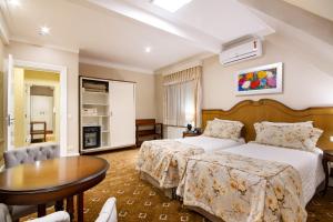 Habitación de hotel con cama y mesa en Pousada Italia Eleganza, en Campos do Jordão