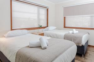 a bedroom with two beds and a large window at Cerros Apart Hotel in Coihaique