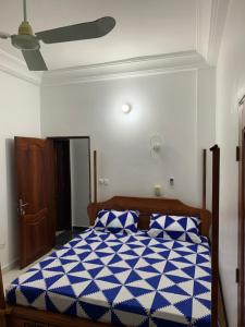 a bedroom with a blue and white bed with a ceiling at Peaceful Stay 2SR in Cotonou