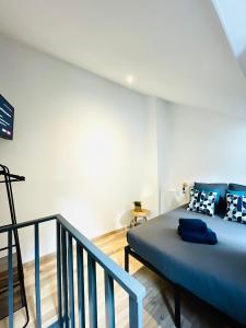 a bedroom with a blue bed and a staircase at BE MY APPARTS, Studio de charme "LE COSY", DOUAI, Coeur de ville in Douai