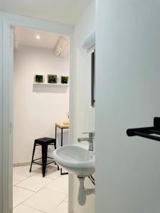 Baño blanco con lavabo y mesa en BE MY APPARTS, Studio de charme "LE COSY", DOUAI, Coeur de ville en Douai