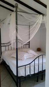 a bedroom with a canopy bed with white sheets at via vione 70 bis in San Bartolomeo al Mare