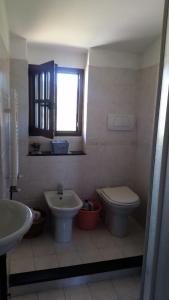 a bathroom with a sink and a toilet and a window at via vione 70 bis in San Bartolomeo al Mare