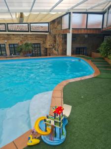 una gran piscina con una casa de juguete frente a ella en Castelodobispo - Ourense en Sobrado del Obispo