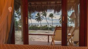 a room with a table and a view of the beach at Villa Kabaceiras in Tatajuba
