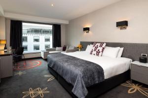a hotel room with a bed and a dresser at SkyCity Hotel Auckland in Auckland