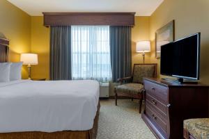 a hotel room with a bed and a flat screen tv at Best Western Plus Grand-Sault Hotel & Suites in Grand Falls