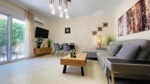 salon z kanapą i stołem w obiekcie Elena apartment chalkidiki w mieście Kallithea