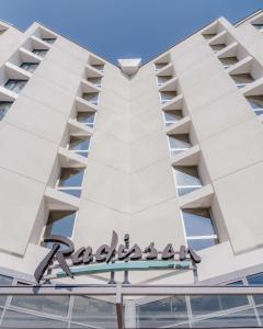 uma vista para a fachada de um edifício com placa arafat em Radisson Hotel Nice Airport em Nice