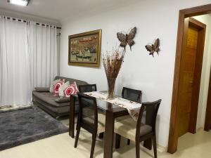 - un salon doté d'une table à manger avec des papillons sur le mur dans l'établissement Apartamento novo no Condomínio Vista do Quilombo a 50 metros do Hard Rock Café, à Gramado