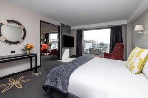 a hotel room with a large bed and a mirror at SkyCity Hotel Auckland in Auckland